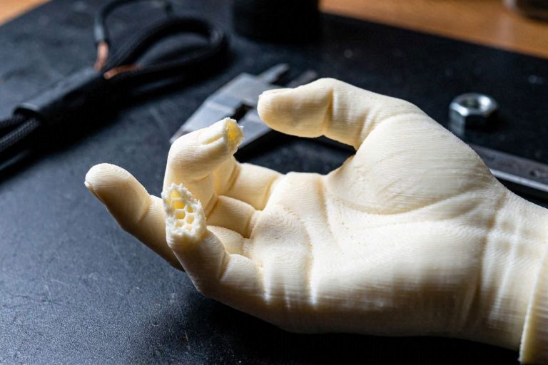 A macro view of a 3D printed model showing why delicate parts snap due to layer adhesion and resolution limits.